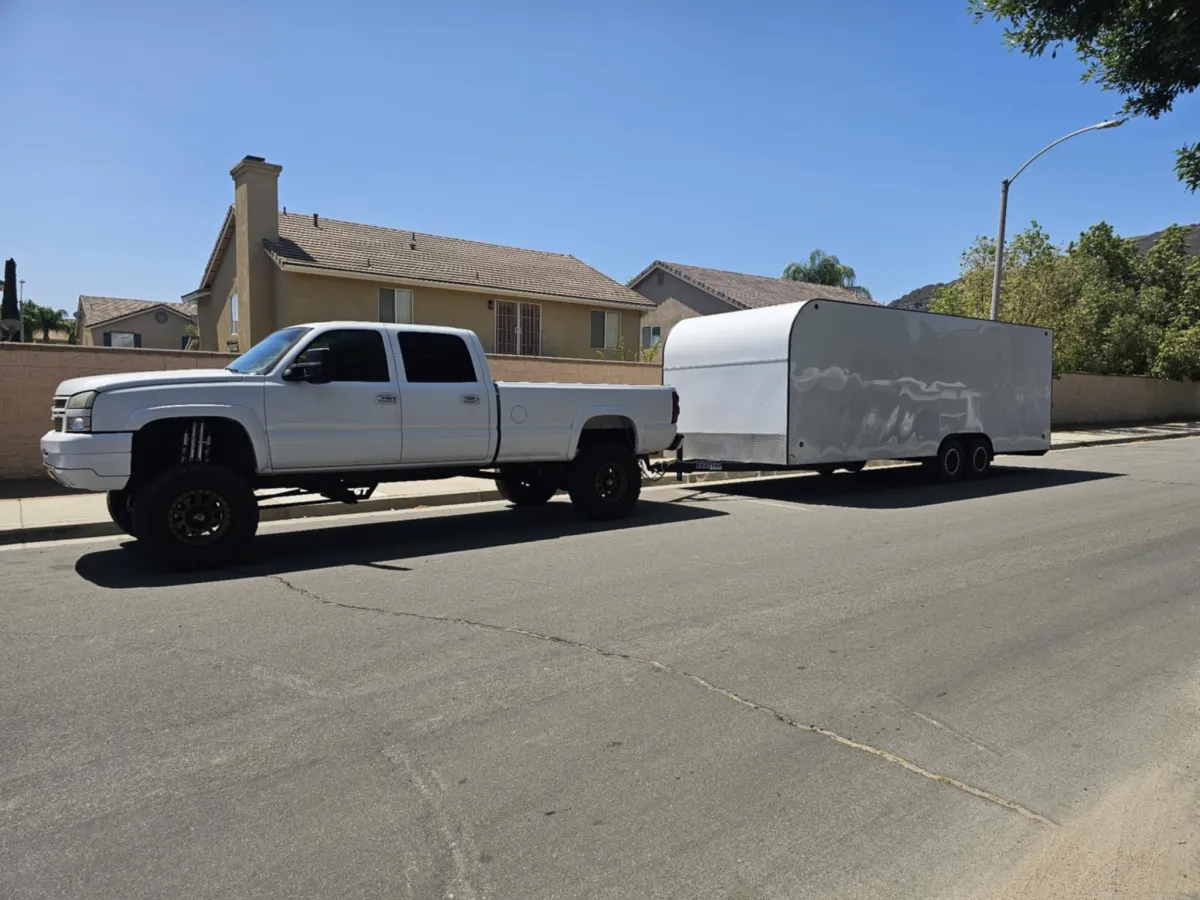 White truck towing car hauler trailer